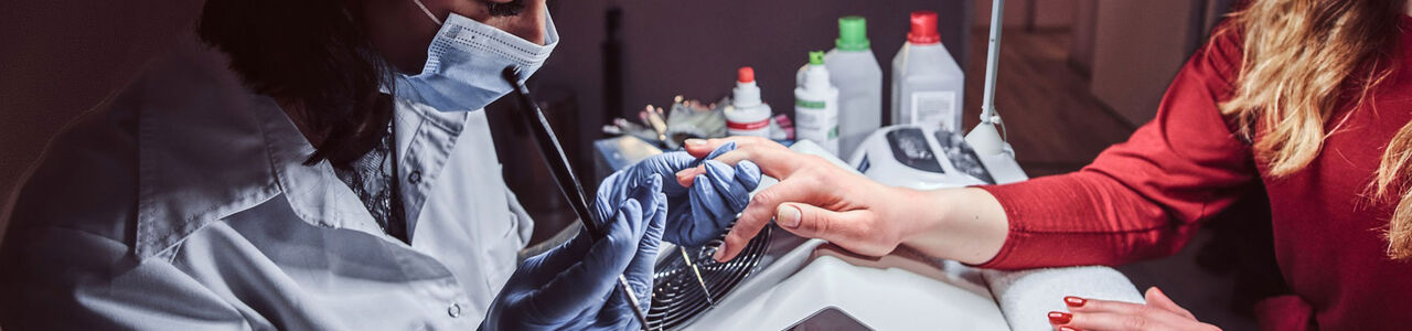 Nagelstylistin trägt in einem professionellen Studio Gel auf die Nägel einer Kundin auf – steht für sichere und EU-konforme Nageldienstleistungen.